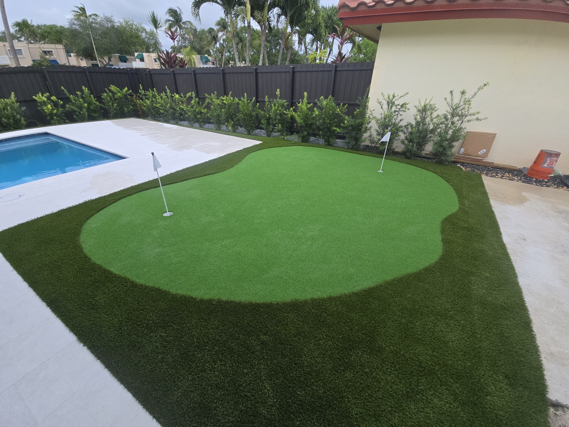 Waterfront backyard artificial grass installation before and after after